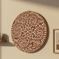 Decorative wall art with floral pattern on a beige wall.